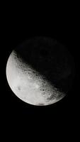 glimpse of the sunlit portion of the moon from outer space, vertical video