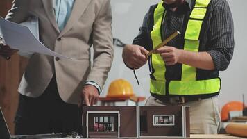 Teamwork men in construction site, Two civil engineer or professional foreman in safety helmet hard hat using blueprint in digital tablet working while standing at industrial factory, teamwork concept video