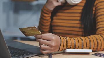 Attractive millennia Asian female holding her smartphone and credit card, using mobile banking app or online shopping app. video