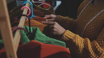 The designer is working and selecting colors for the clothing design in a good mood smiling with happiness at creating the work video