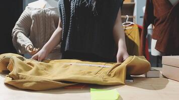 The designer is working and selecting colors for the clothing design in a good mood smiling with happiness at creating the work video