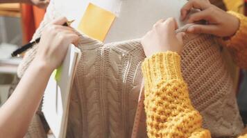 The designer is working and selecting colors for the clothing design in a good mood smiling with happiness at creating the work video