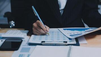 Asian accountant working and analyzing financial reports project accounting with chart graph in modern office, finance and business concept. video