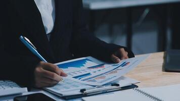 Asian accountant working and analyzing financial reports project accounting with chart graph in modern office, finance and business concept. video