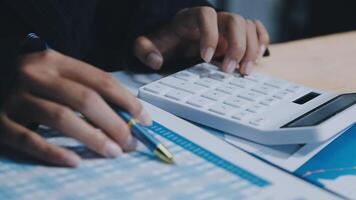 Asian accountant working and analyzing financial reports project accounting with chart graph in modern office, finance and business concept. video