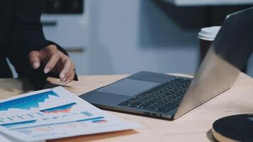 Asian accountant working and analyzing financial reports project accounting with chart graph in modern office, finance and business concept. video