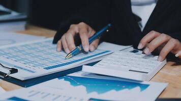 Asian accountant working and analyzing financial reports project accounting with chart graph in modern office, finance and business concept. video