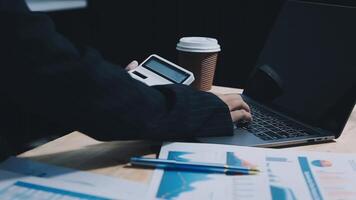 Asian accountant working and analyzing financial reports project accounting with chart graph in modern office, finance and business concept. video