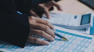 contador asiático trabalhando e analisando contabilidade de projeto de relatórios financeiros com gráfico gráfico no conceito moderno de escritório, finanças e negócios. video