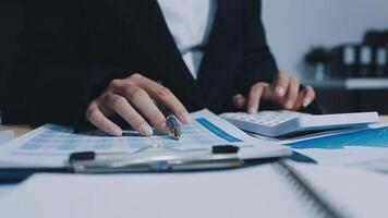 Asian accountant working and analyzing financial reports project accounting with chart graph in modern office, finance and business concept. video