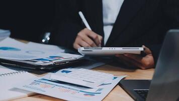 Asian accountant working and analyzing financial reports project accounting with chart graph in modern office, finance and business concept. video