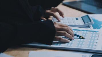 Asian accountant working and analyzing financial reports project accounting with chart graph in modern office, finance and business concept. video