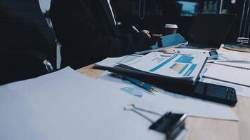 Asian accountant working and analyzing financial reports project accounting with chart graph in modern office, finance and business concept. video