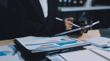 Asian accountant working and analyzing financial reports project accounting with chart graph in modern office, finance and business concept. video