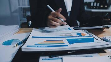 Asian accountant working and analyzing financial reports project accounting with chart graph in modern office, finance and business concept. video