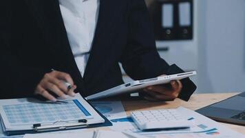 Asian accountant working and analyzing financial reports project accounting with chart graph in modern office, finance and business concept. video