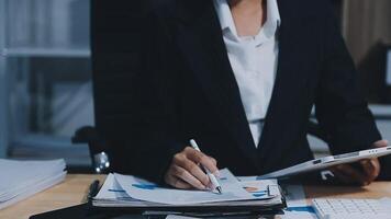 Asian accountant working and analyzing financial reports project accounting with chart graph in modern office, finance and business concept. video