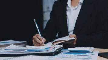 Asian accountant working and analyzing financial reports project accounting with chart graph in modern office, finance and business concept. video