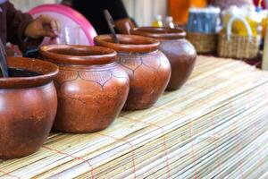 A row of clay pots containing food in a traditional market photo