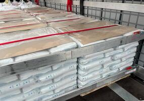 Loading, transportation and unloading of bulk materials in bags of 25 kilograms in a semi-trailer. Securing the cargo with straps and locks for stability photo