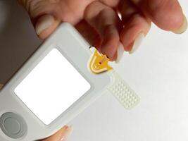 Measurement of blood sugar levels using a glucose meter with a mock-up. Piercing a finger to draw blood photo