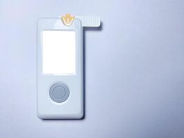 Measurement of blood sugar levels using a glucose meter with a mock-up. Piercing a finger to draw blood photo