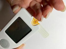 Measurement of blood sugar levels using a glucose meter with a mock-up. Piercing a finger to draw blood photo