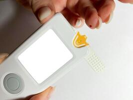 Measurement of blood sugar levels using a glucose meter with a mock-up. Piercing a finger to draw blood photo