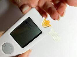 Measurement of blood sugar levels using a glucose meter with a mock-up. Piercing a finger to draw blood photo