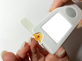 Measurement of blood sugar levels using a glucose meter with a mock-up. Piercing a finger to draw blood photo
