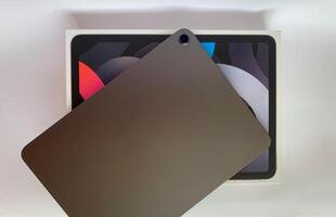The tablet is black on a white isolated background with a mock up. Back side view of the tablet photo