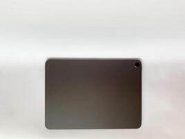 The tablet is black on a white isolated background with a mock up. Back side view of the tablet photo