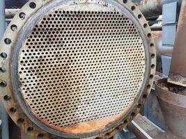 Shell-and-tube heat exchanger for heat exchange between two streams close-up. Dirty pipes in the opened heat exchanger photo