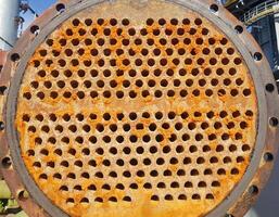 Shell-and-tube heat exchanger for heat exchange between two streams close-up. Dirty pipes in the opened heat exchanger photo