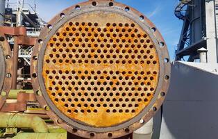 Shell-and-tube heat exchanger for heat exchange between two streams close-up. Dirty pipes in the opened heat exchanger photo