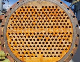 Shell-and-tube heat exchanger for heat exchange between two streams close-up. Dirty pipes in the opened heat exchanger photo