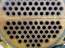 Shell-and-tube heat exchanger for heat exchange between two streams close-up. Dirty pipes in the opened heat exchanger photo