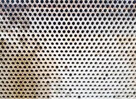 Shell-and-tube heat exchanger for heat exchange between two streams close-up. Dirty pipes in the opened heat exchanger photo