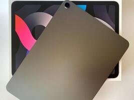 The tablet is black on a white isolated background with a mock up. Back side view of the tablet photo