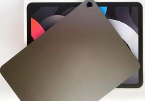 The tablet is black on a white isolated background with a mock up. Back side view of the tablet photo
