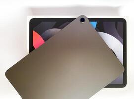 The tablet is black on a white isolated background with a mock up. Back side view of the tablet photo