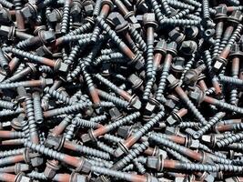 Background of a large number of industrial screws in close-up. Bolt texture photo