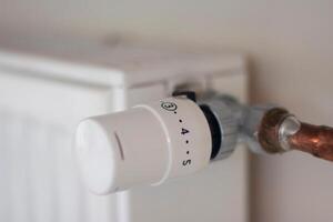 Adjusting the radiator temperature using a thermostat in an apartment with central heating photo