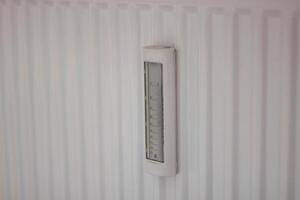 Adjusting the radiator temperature using a thermostat in an apartment with central heating photo