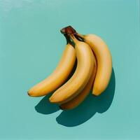 A Bunch of Ripe Yellow Bananas on a Turquoise Background photo