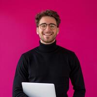 Smiling Man With Laptop In Front Of Pink Background photo