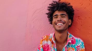 Smiling Man Leaning Against Pink And Orange Wall photo