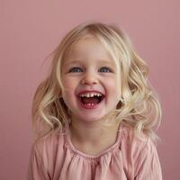 Portrait of a Young Girl With Blonde Hair Laughing in Front of a Pink Background photo