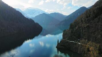 Clear blue mountain lake with reflection of clouds on the water. Drone view video