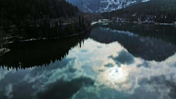Clear blue mountain lake with reflection of clouds on the water. Drone view video